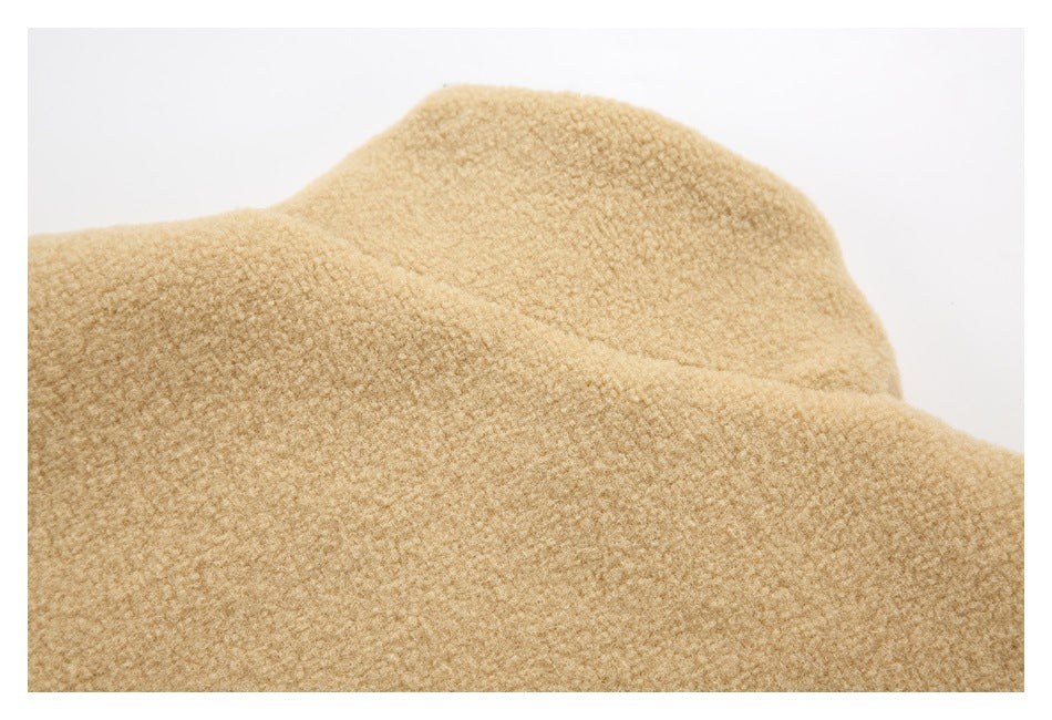 Close-up of tan fleece fabric showing its thick, curly surface and rounded garment shape.