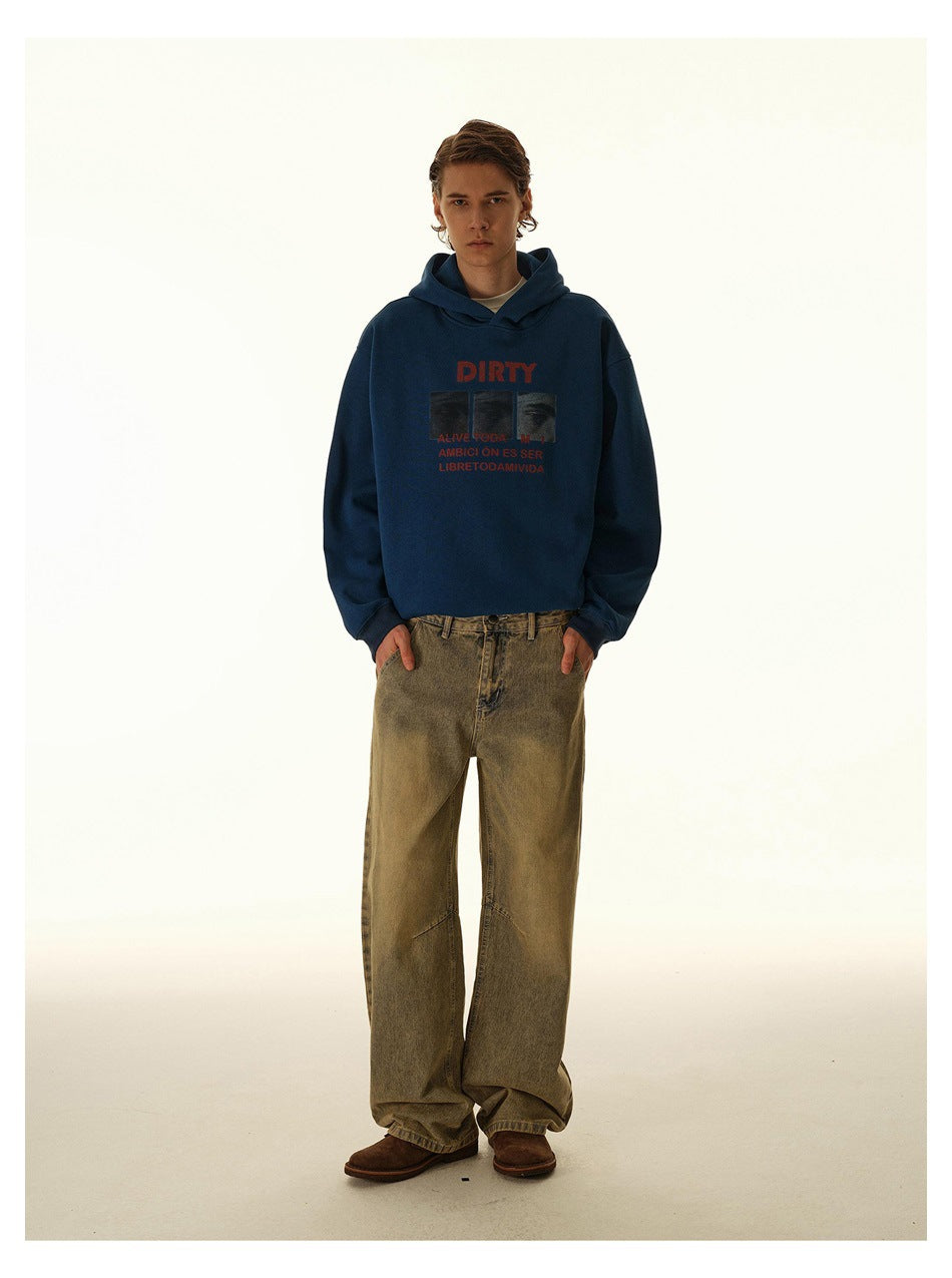 Model wearing a navy hoodie with red graphic text and loose tan jeans, shown full length from the front.