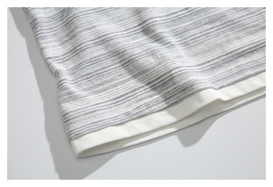 Close-up of the gray-and-white striped top's lower edge and wide cream hem band.