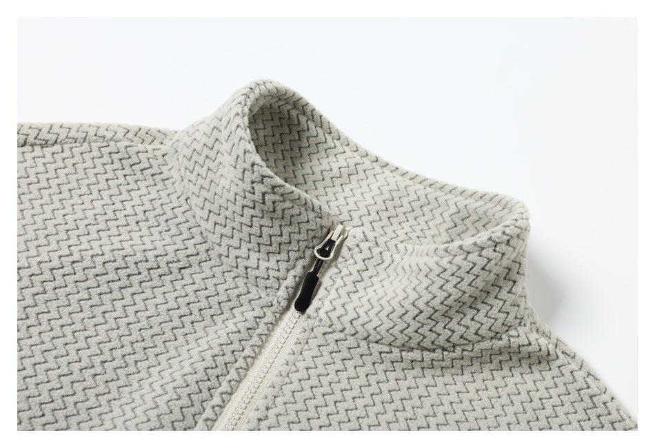 Close-up of the cream and gray zigzag pullover's raised collar and white zipper with a black pull.