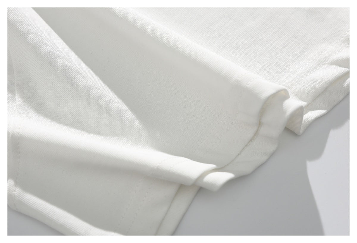 Close-up of white garment edges with visible stitching and folded hems.