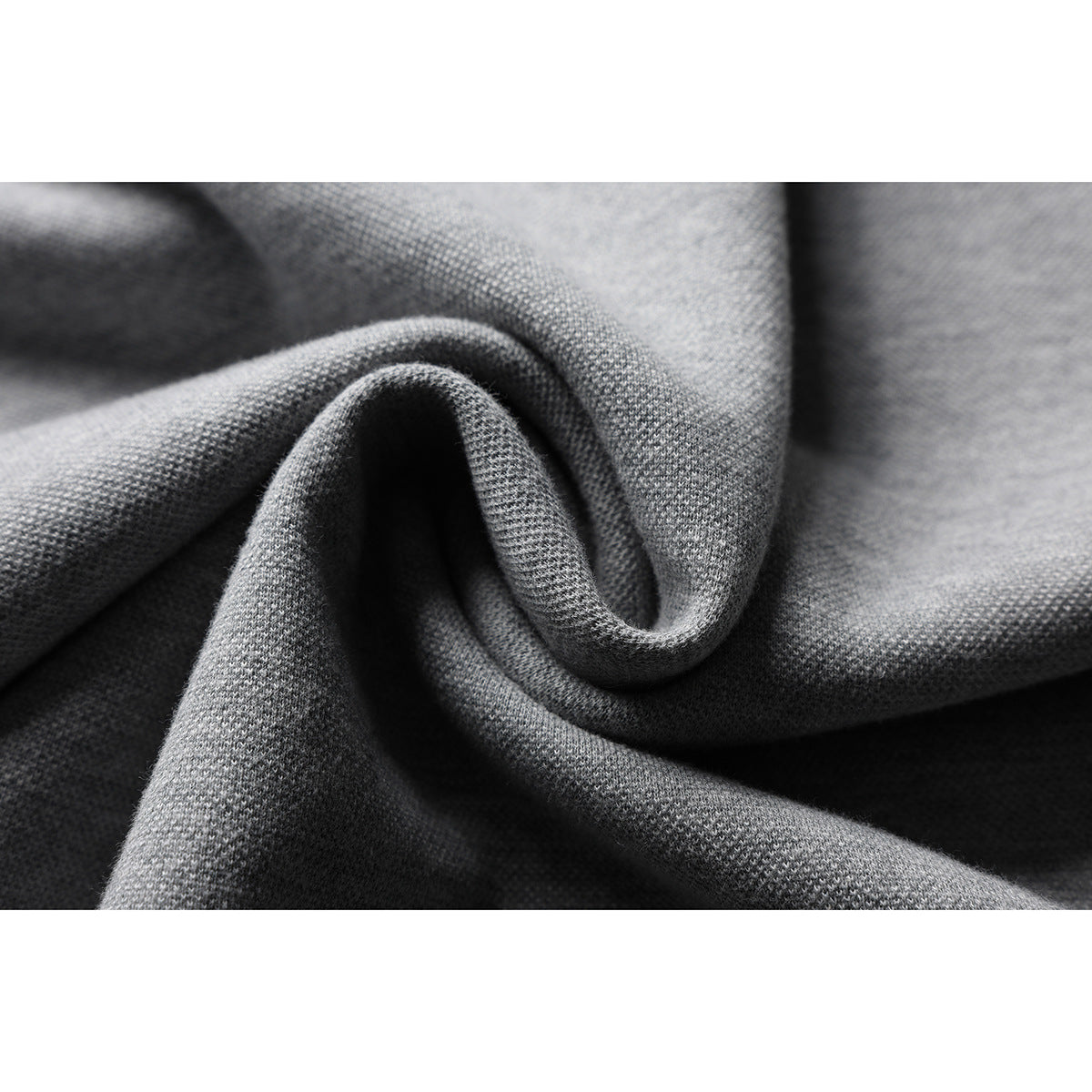 Macro view of the gray shirt's knit fabric texture, folded into soft ridges.