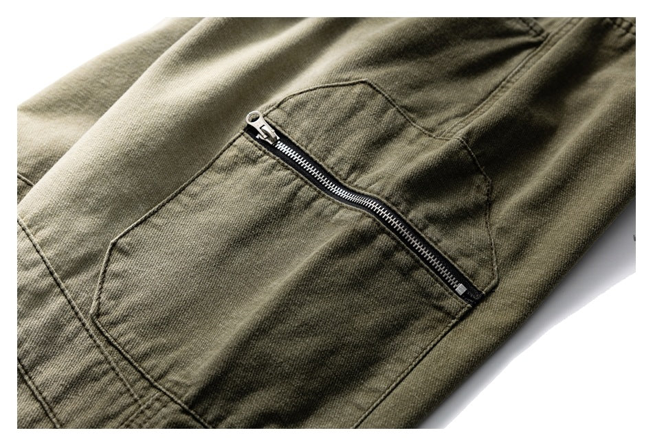 Close-up of olive-brown trousers featuring a large pocket with a diagonal metal zipper.