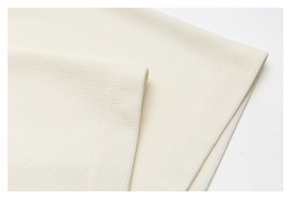 Close-up of an ivory shirt sleeve cuff and hem showing the fabric texture and stitching.