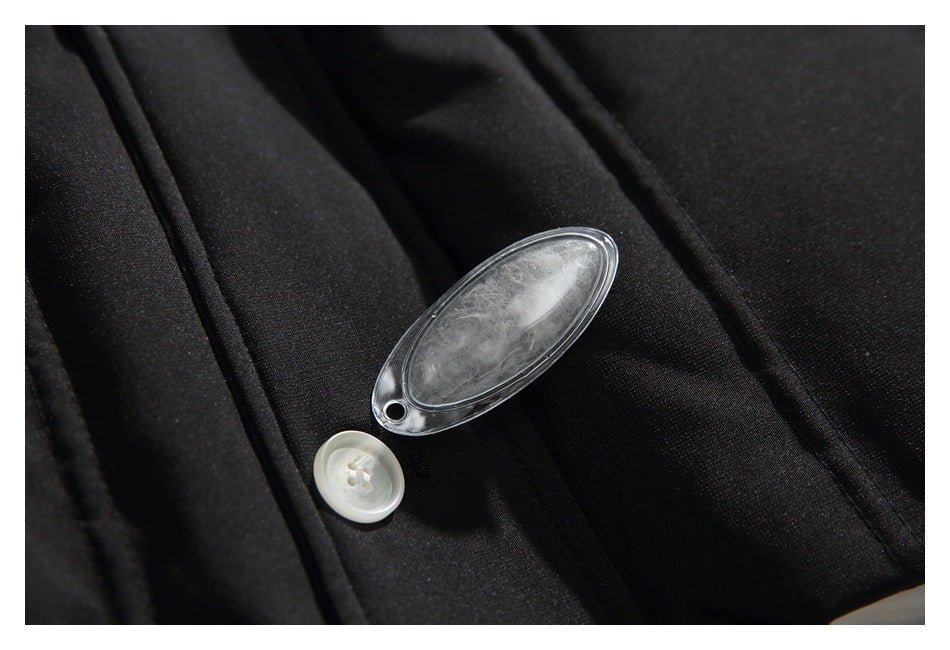Close-up of black garment fabric beside a white button and a clear oval tag containing white fibers.