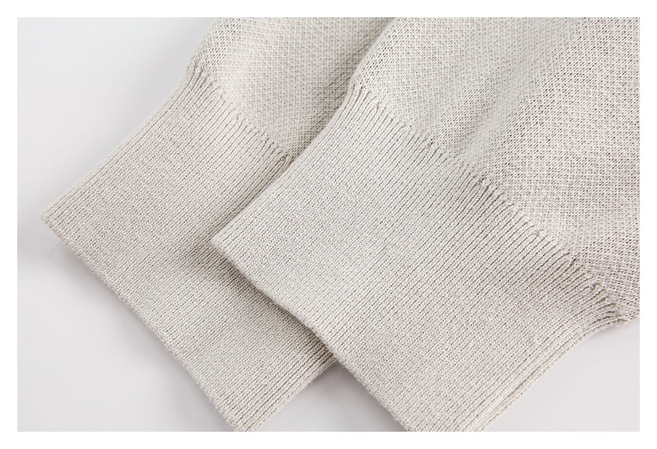 Close-up of two ribbed cuffs on the cream sweater, showing the knit texture.