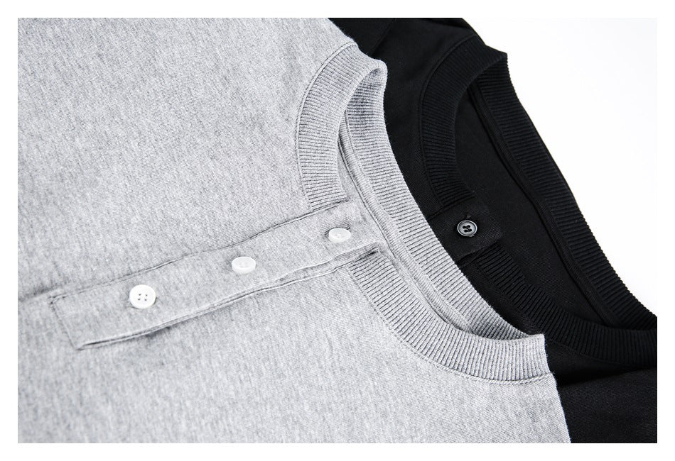 Close-up of gray and black tops showing ribbed necklines and short button plackets.