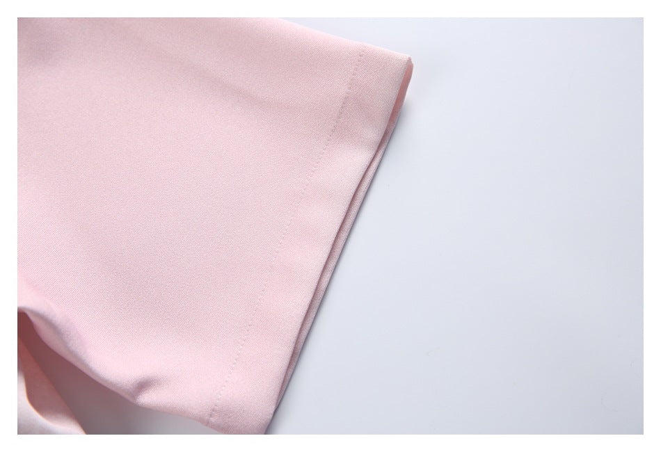 Close-up of a pale pink shirt sleeve and its stitched hem.