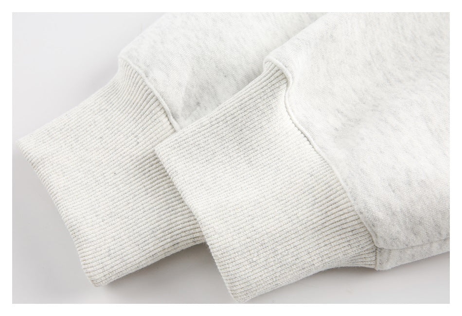 Close-up of two light heather-gray sweatshirt cuffs with ribbed knit trim.