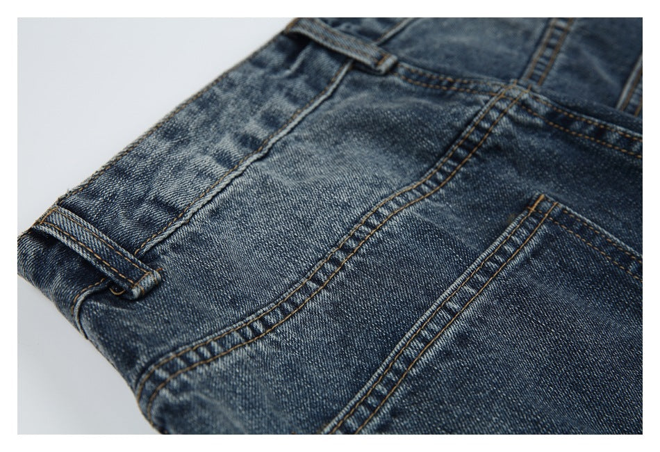 Close-up of blue denim jeans showing the waistband, belt loop, and stitched seams.