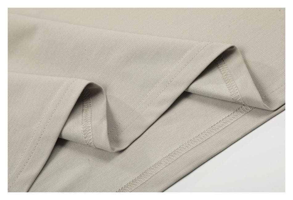 Inside view of a light beige garment hem with visible overlock stitching.