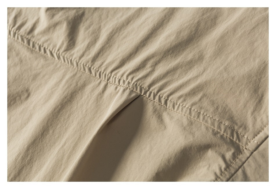 Close-up of a gathered stitched seam on light tan fabric.