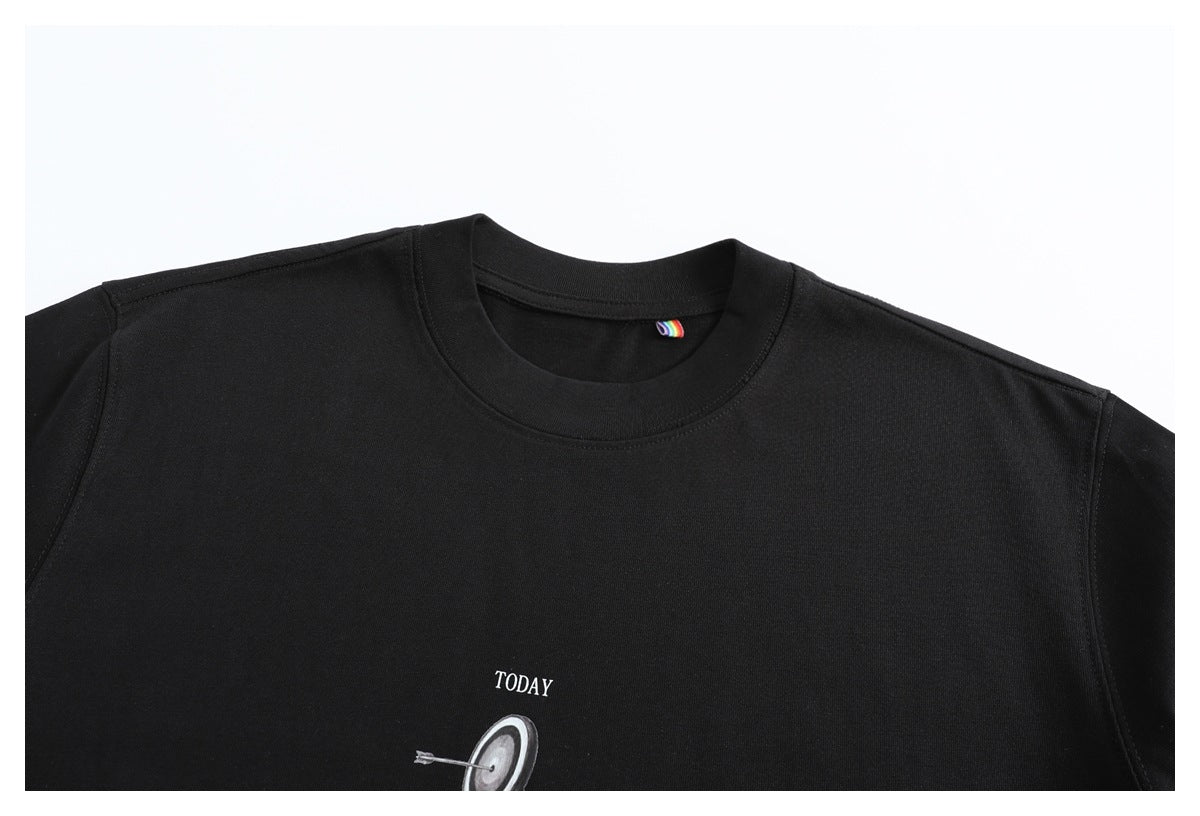 Cropped close-up of a black crew-neck T-shirt front, with part of a white “TODAY” target graphic visible near the lower edge.