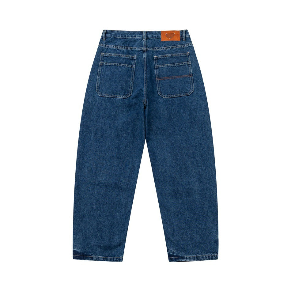 Back flat view of dark blue denim jeans with two patch pockets and a brown patch at the waistband