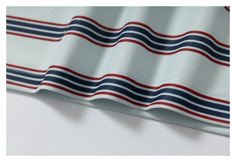Close-up of pale fabric with wavy red and navy stripes and a folded edge.