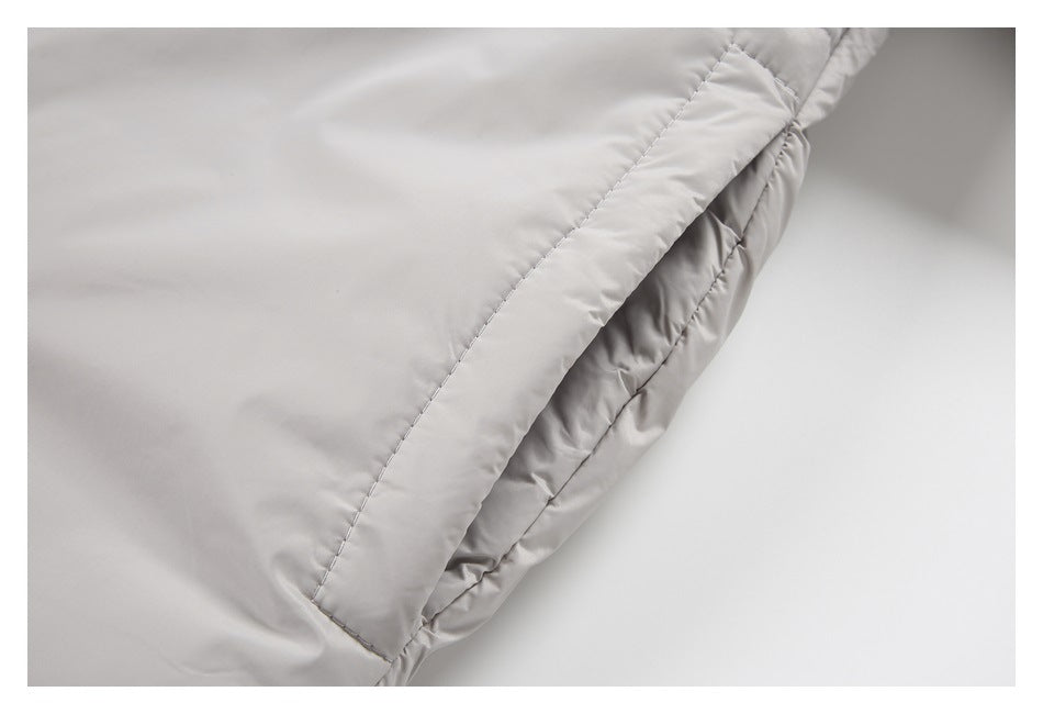 Close-up of a stitched edge and gathered lining on the light gray jacket.