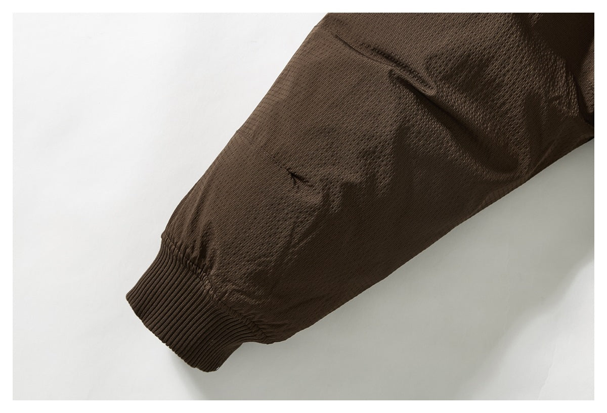 Close-up of a dark brown jacket sleeve and its ribbed cuff.