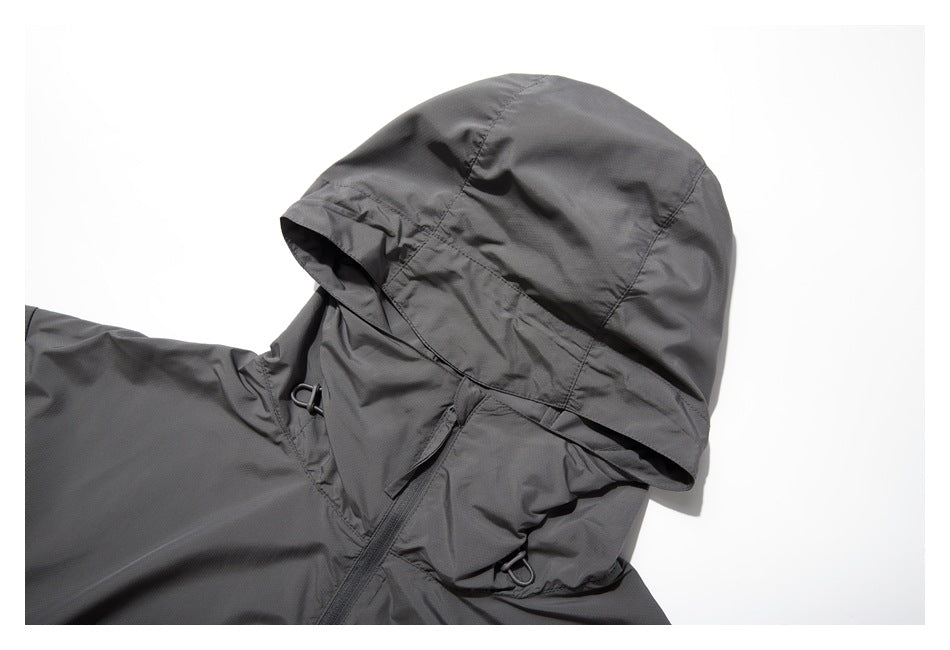 Close-up of the gray jacket's hood, showing panel seams, a visor-like brim, and cord-adjustment hardware.