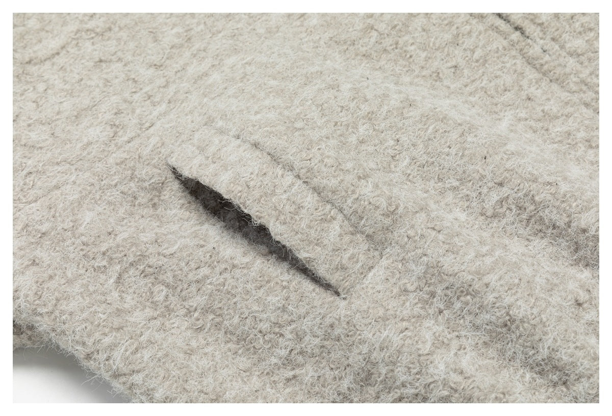 Close-up of a narrow opening in a light beige, fuzzy-textured garment.