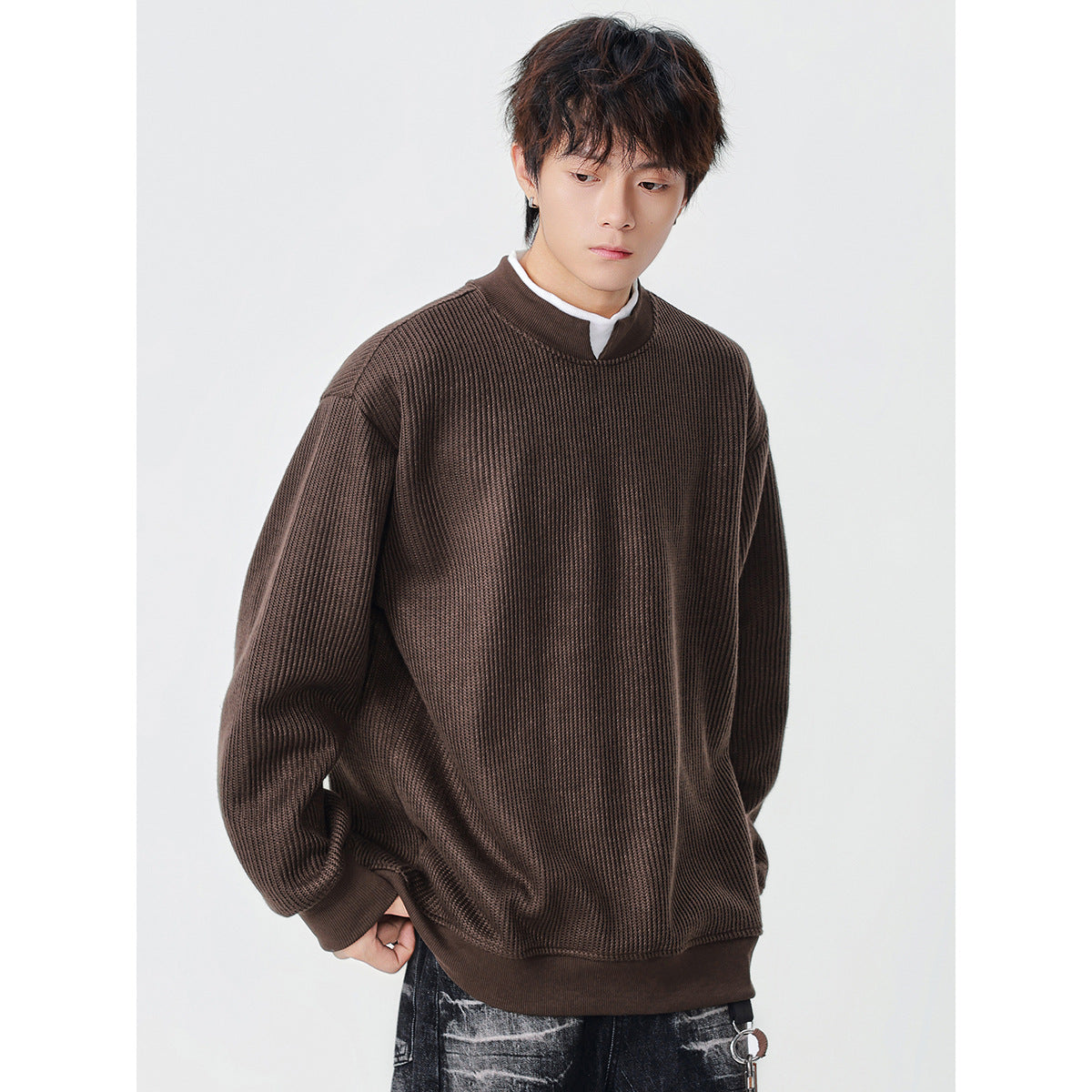 Model wearing an oversized dark brown ribbed sweatshirt with a stand collar and ribbed cuffs and hem.