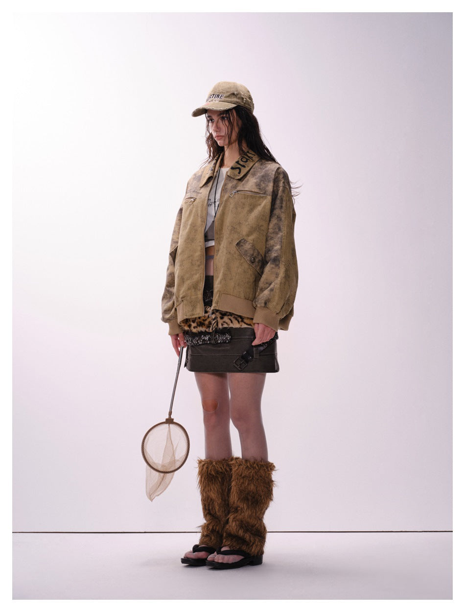 Model wearing the brown mud-dyed jacket in a three-quarter side view, showing the collar lettering and flap pocket