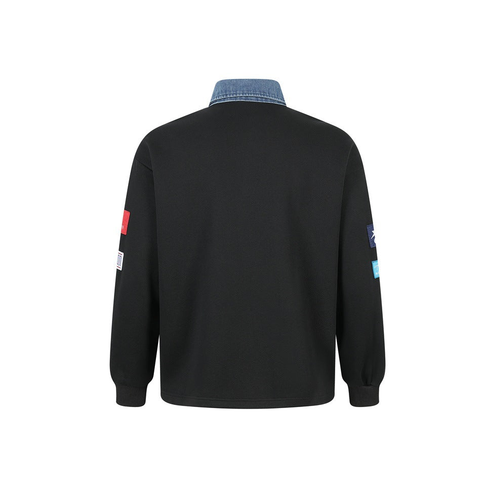 Back view of a black long-sleeve pullover with a blue denim collar and small patches visible on the sleeves.