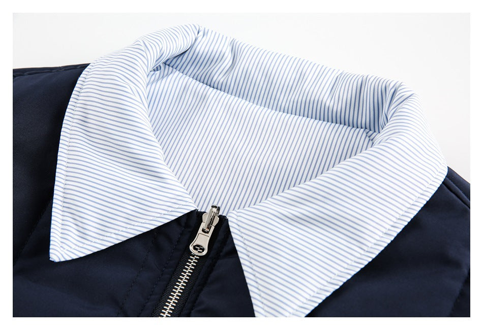 Close-up of the jacket’s pale blue pinstriped collar, navy body and metal zipper.