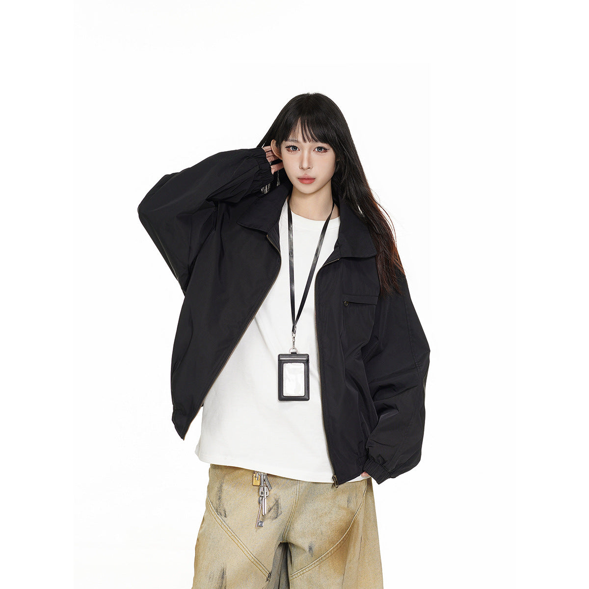 Model wearing an open black oversized zip jacket with a wide collar and chest pocket over a white shirt.
