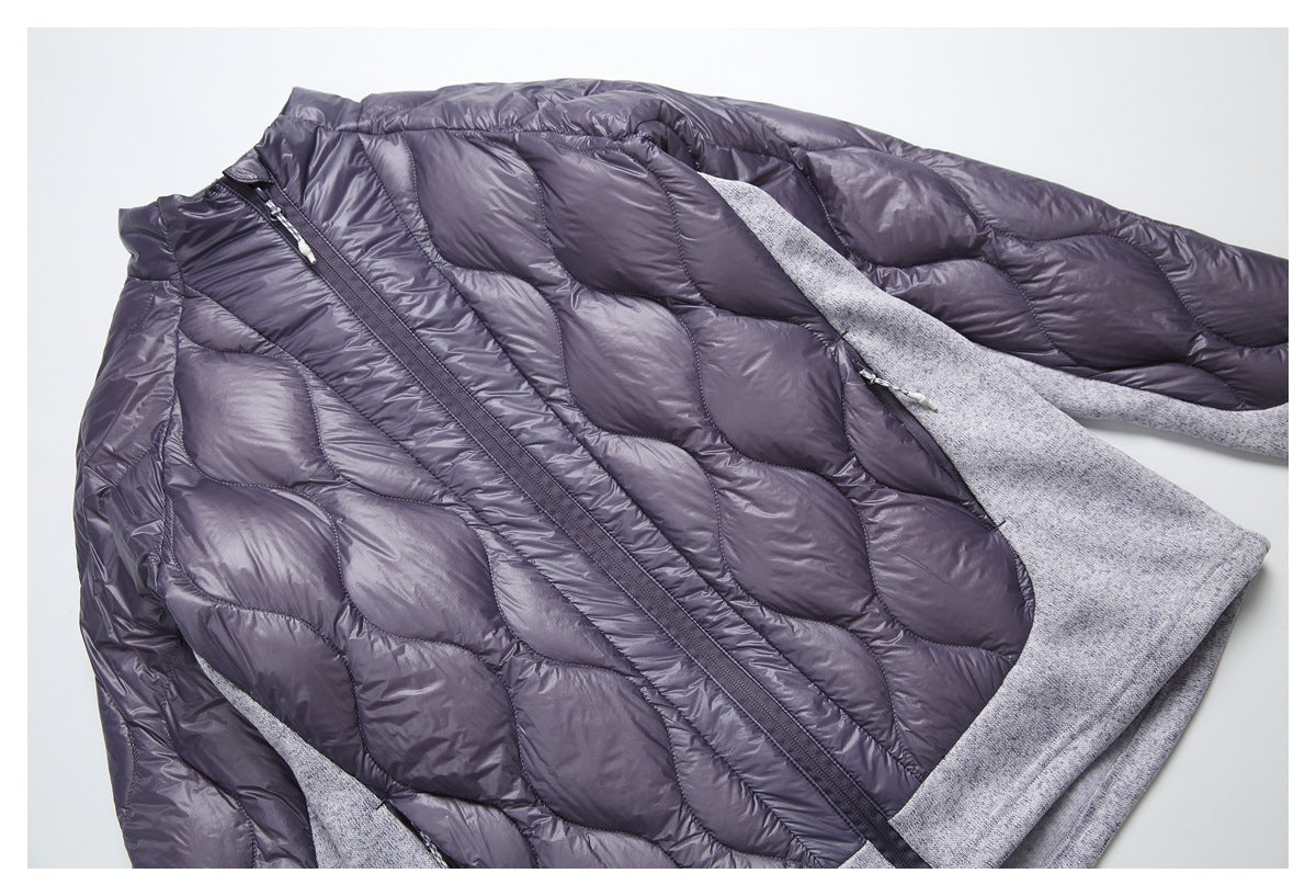 Close view of the gray jacket opened to show its quilted interior, front zipper, and contrasting knit panels.