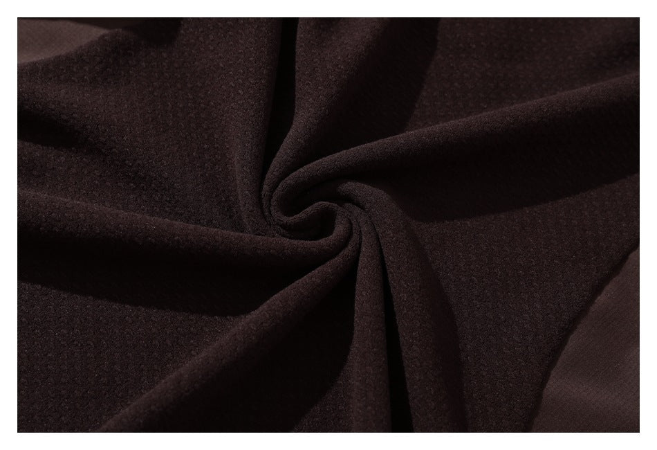 Close-up of dark brown textured fabric gathered into a central twist.