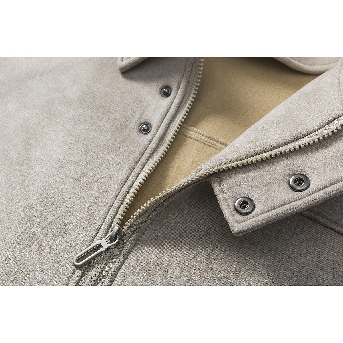 Close-up of the taupe jacket's zipper, snap fasteners, and beige inner lining.
