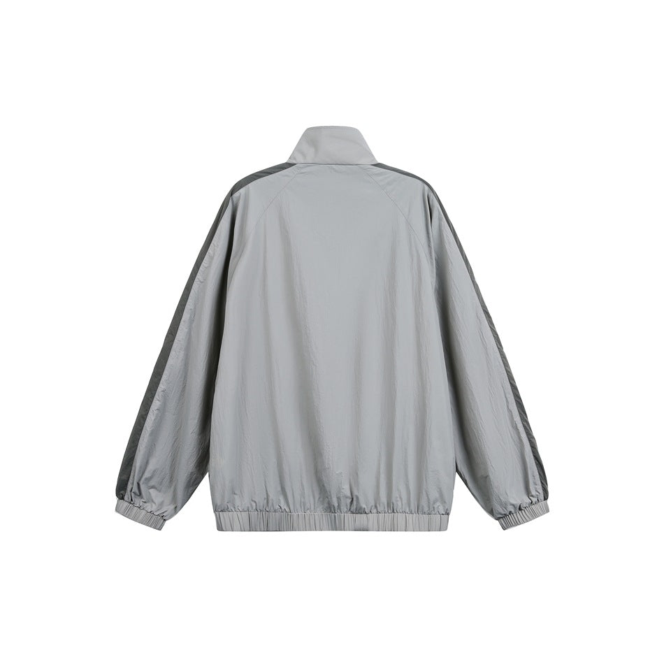 Back view of a light gray jacket with dark shoulder and sleeve stripes, elastic cuffs, hem, and stand collar.