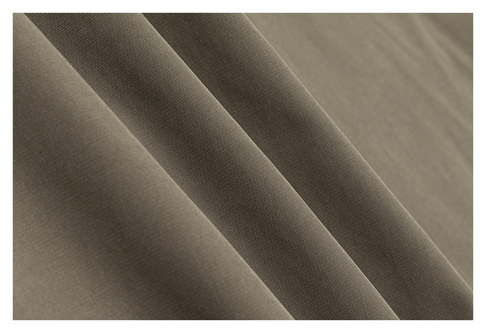 Close-up of taupe-gray fabric showing a fine, even texture and soft diagonal folds.