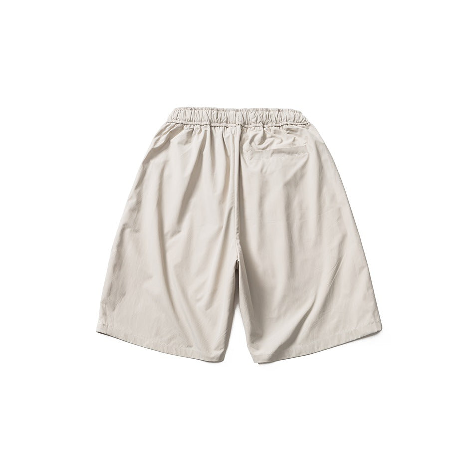 Back view of light beige wide-leg shorts with a gathered elastic waistband and a small rear pocket.