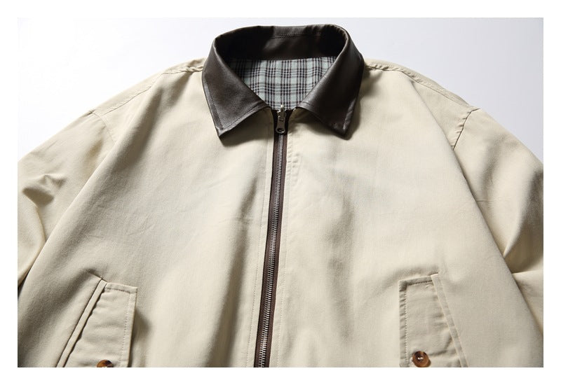 Close-up of a beige jacket's dark collar and front zipper, with plaid lining visible inside the collar.