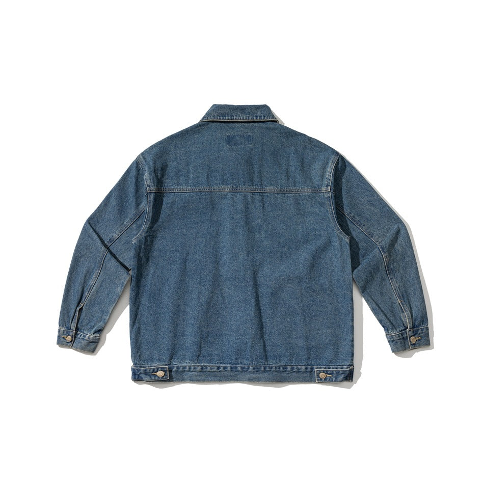 Flat lay of the blue denim jacket from the back, showing its yoke, long sleeves, cuffs, and hem tabs.