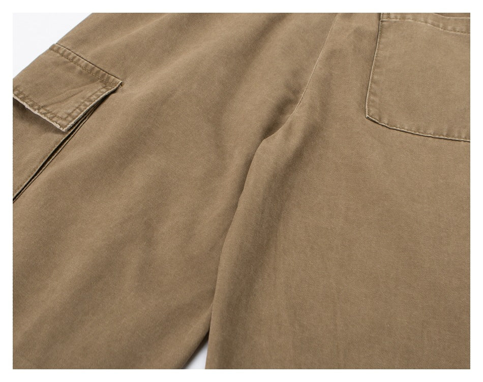 Close-up of tan trousers showing a side cargo pocket and rear pocket stitching.