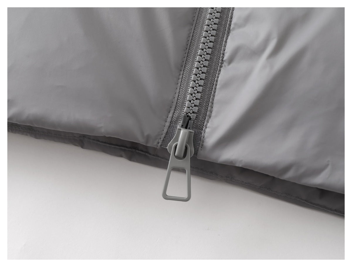 Close-up of the lower front of a gray jacket, showing the chunky zipper and large pull tab.
