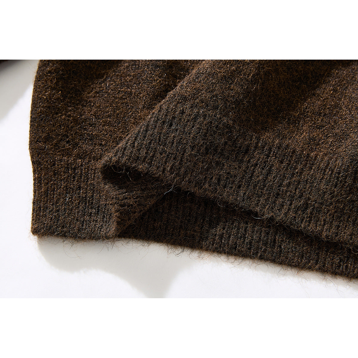 Close-up of the brown knit sweater's ribbed cuff and textured sleeve.