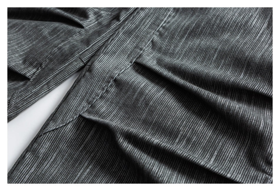 Close-up of gray striped pants fabric gathered in folds, showing seams and stitching.