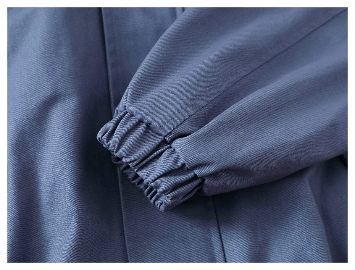 Close-up of the slate-blue jacket’s sleeve with a gathered elastic cuff.