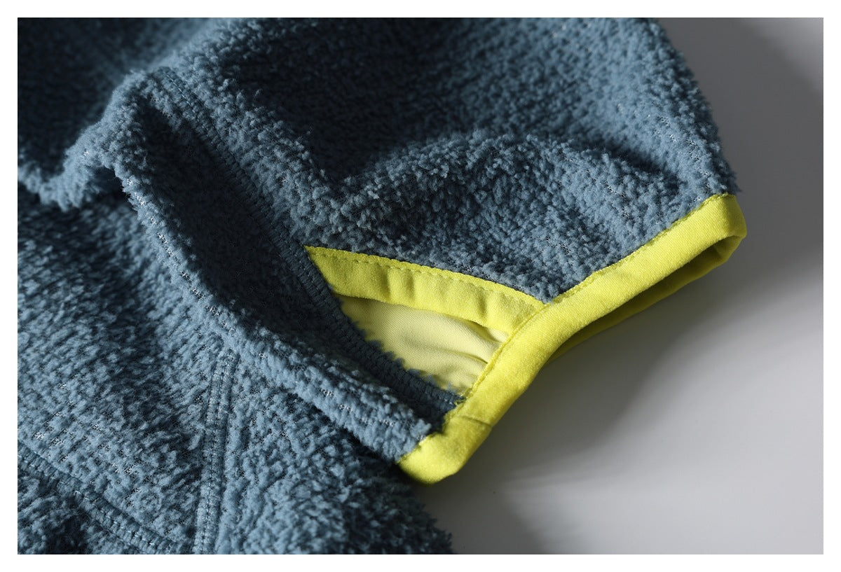 Close-up of blue textured jacket fabric with a bright yellow bound edge and seam detail.