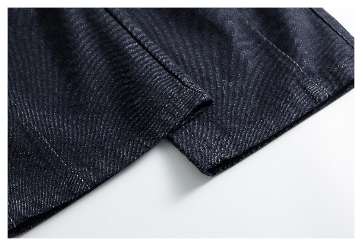 Close-up of dark indigo trouser hems with visible stitching and folded fabric edges.