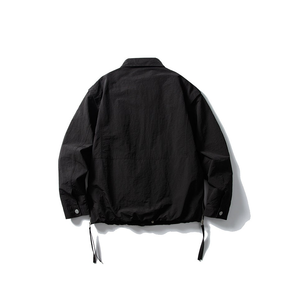 Back view of black collared jacket with back panel seam, snap cuffs and hem side straps