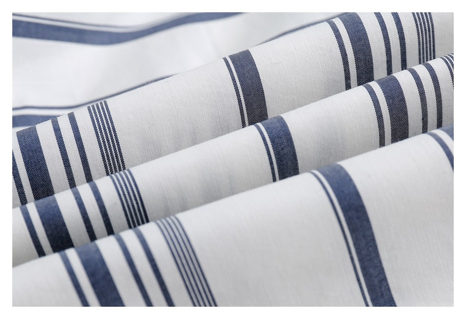 Close-up of white fabric with navy and gray stripe patterns arranged in soft folds.