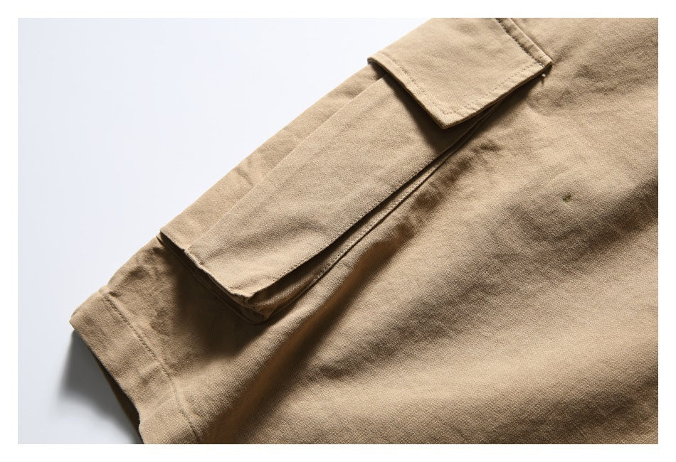 Close-up of a large flap cargo pocket on tan trousers.