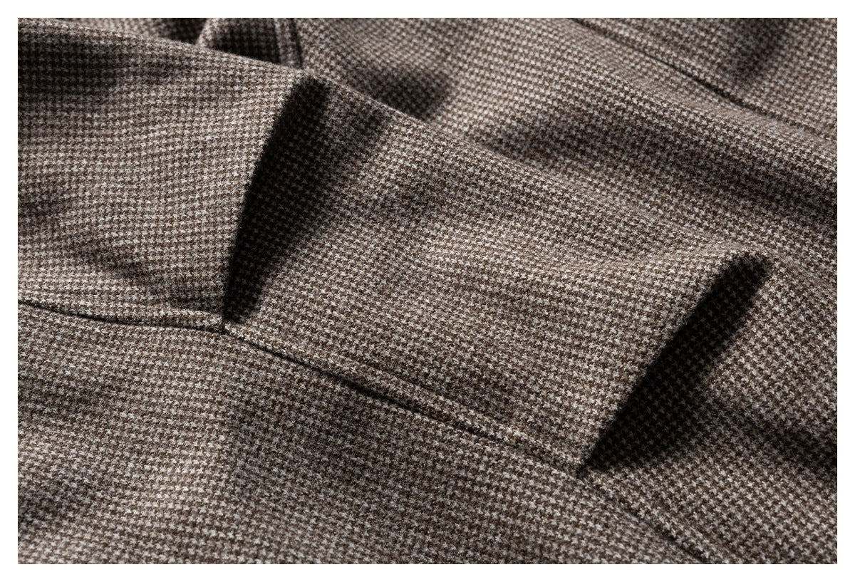 Close-up of the jacket's brown-and-cream houndstooth fabric and stitched seam details.