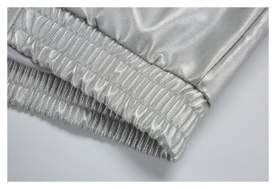 Close-up of a silver garment with a gathered elastic edge and stitched seam.