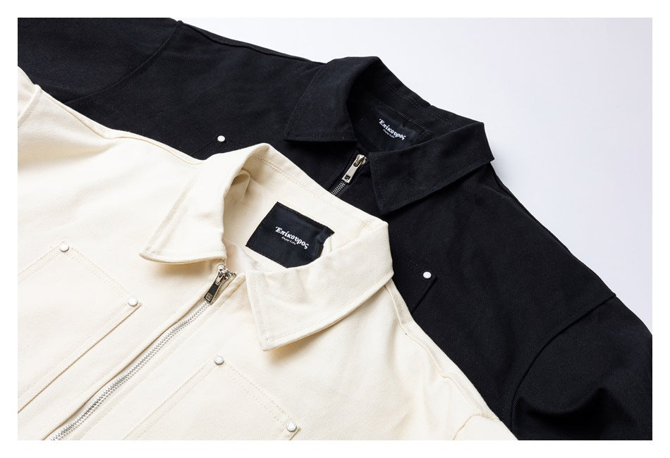 Close-up of black and ivory collared jackets showing their zippers, snaps, and inner labels.