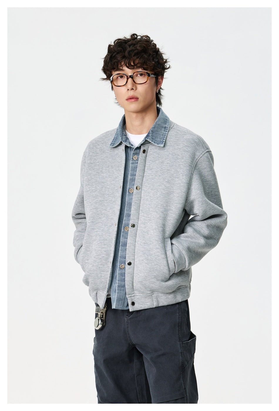 Model wearing gray snap-front jacket with denim-look collar over white tee and dark pants